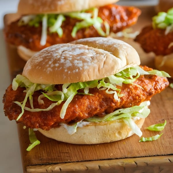 A Nashville hot chicken sandwich from Rude Rooster, with lettuce and sauce on a bun.